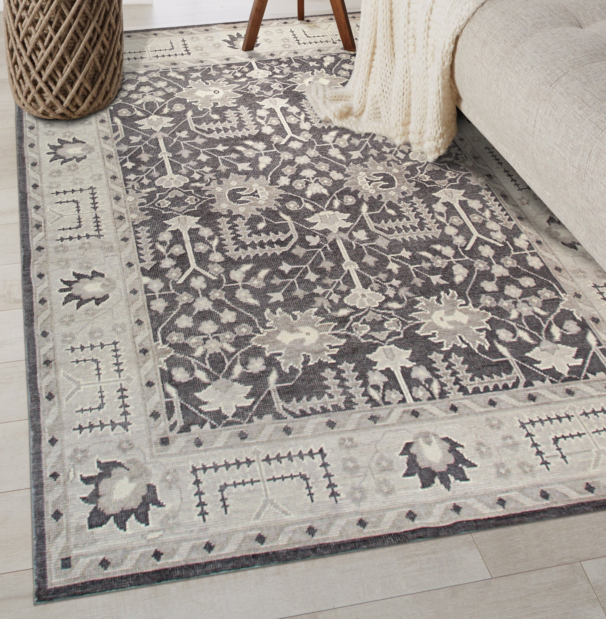 Cozy Oushak Charcoal Hand Knotted Wool Rug, a charcoal wool rug with an Oushak design, partially visible and hinting at its texture and craftsmanship.
