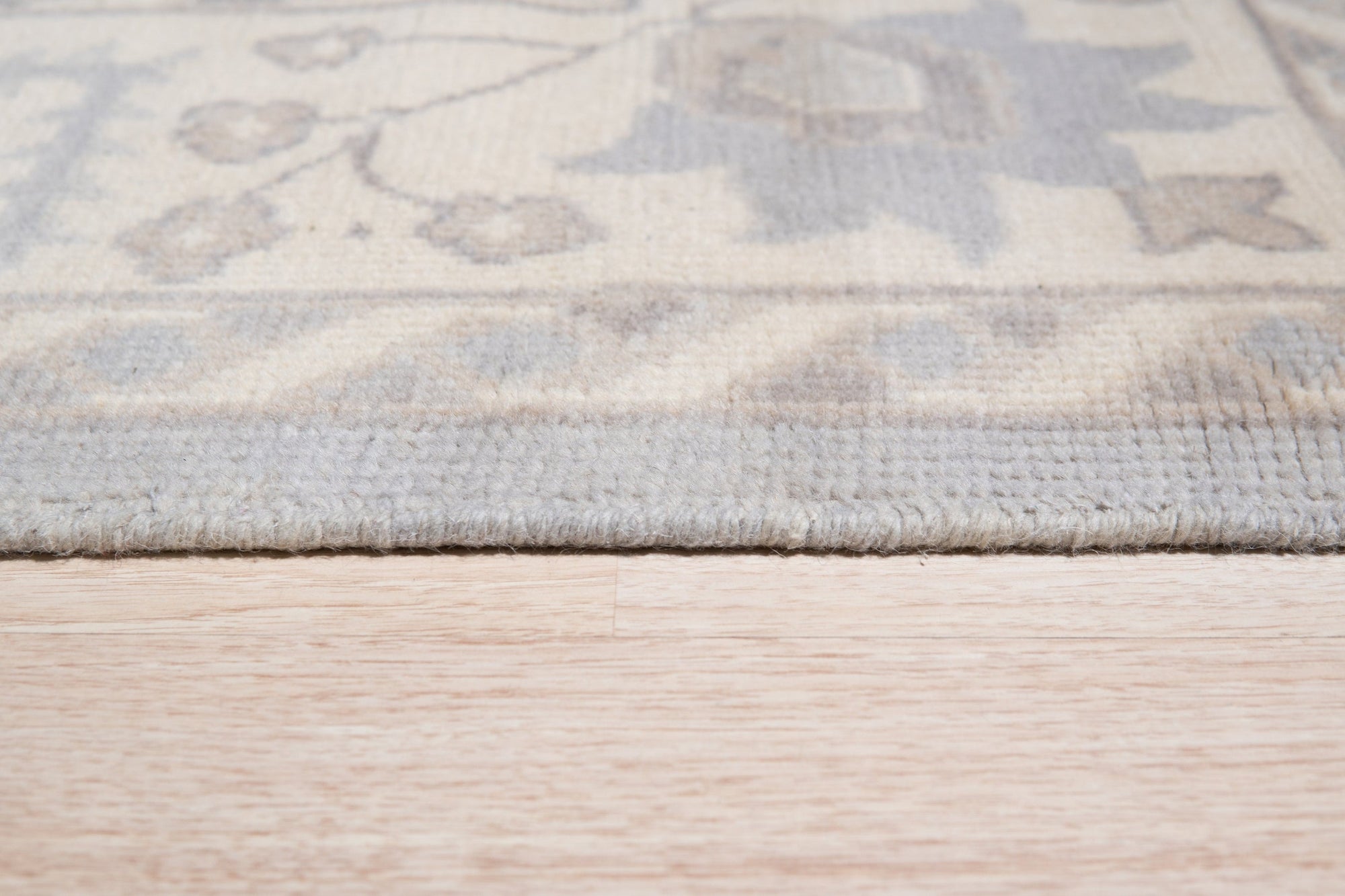 Harlow Traditional Gray Hand Knotted Wool Rug, its intricate patterns and soft gray hues lending a timeless elegance to a warmly lit living space.