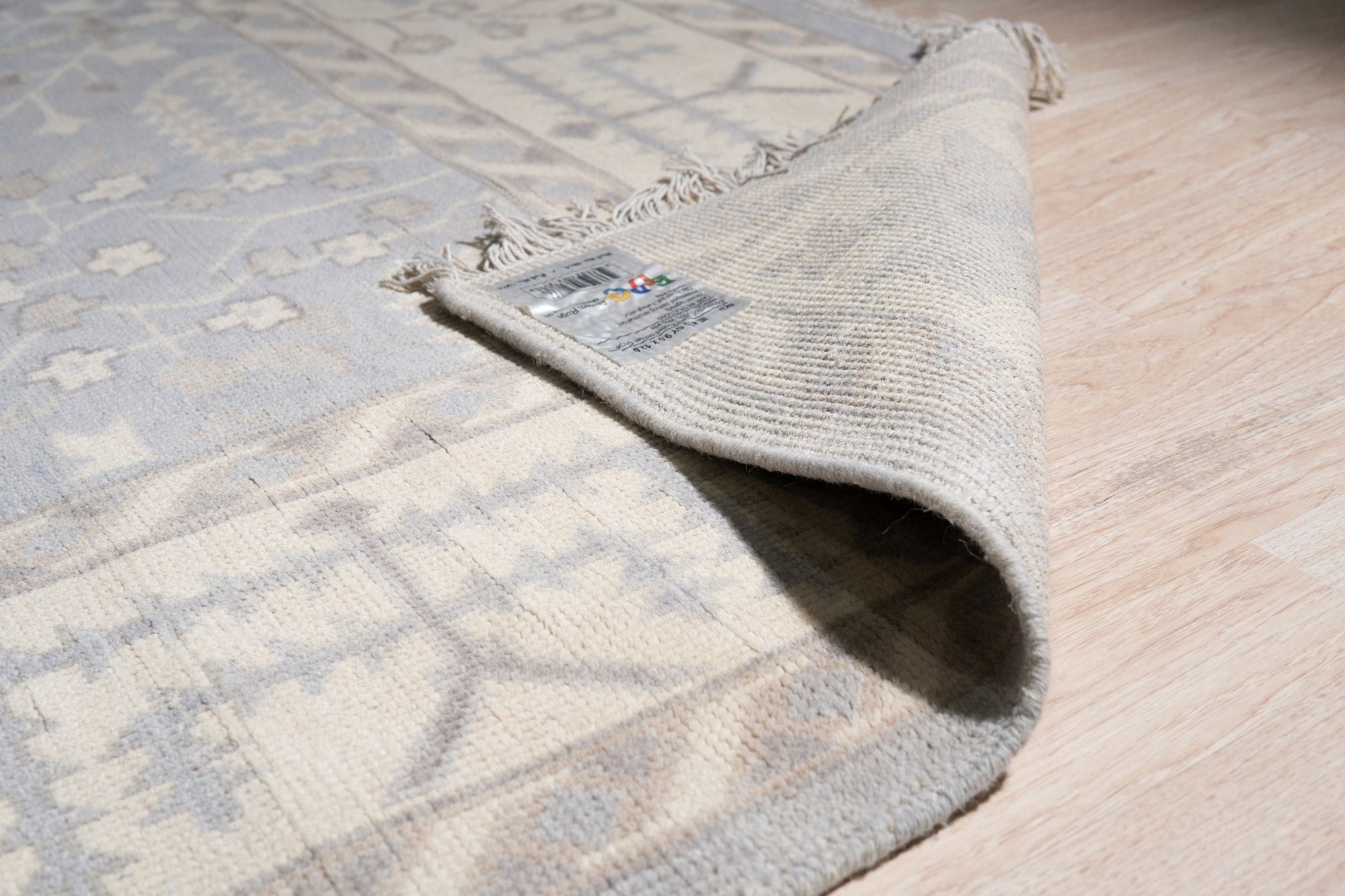 Harlow Traditional Gray Hand Knotted Wool Rug, its intricate floral patterns and muted gray tones adding warmth and sophistication to a softly lit living space.