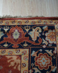 Majestic Versatile Red Hand Knotted Wool Rug, showcasing intricate patterns in deep reds and subtle variations, resting on a polished wooden floor, suggesting warmth and elegance in a home setting.