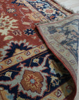Kira Zinnia Rust Hand Knotted Wool Rug, vibrant red wool rug displaying intricate hand-knotted craftsmanship, shown within a bright, modern interior setting.