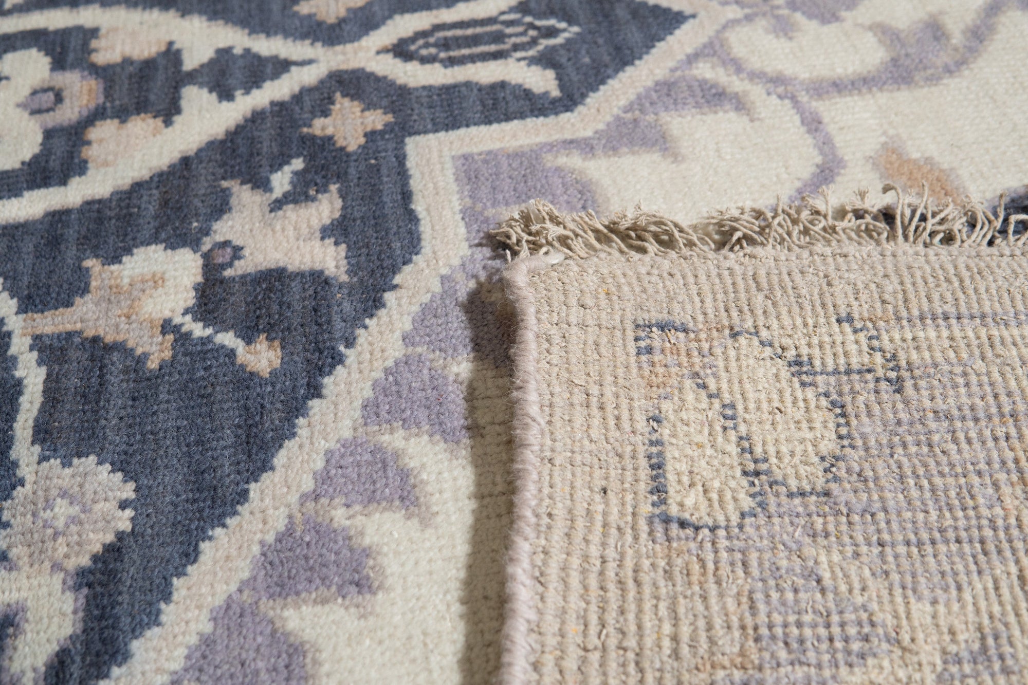 Timeless Oriental Ivory Hand Knotted Wool Rug, with intricate floral medallions and a neutral ivory palette, softly illuminates a living room setting, highlighting the rug's texture and detail.