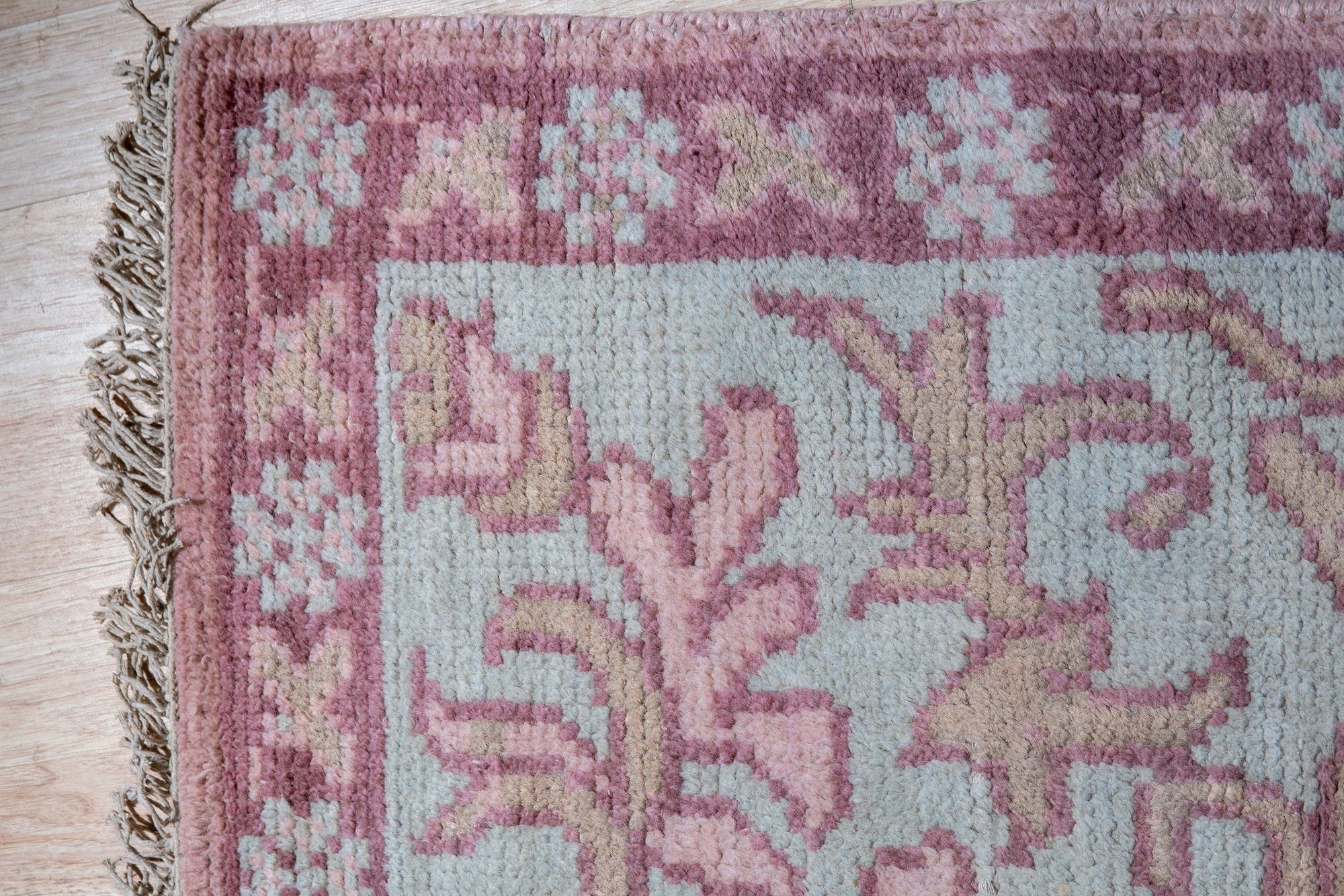 Lydia Oriental Pink Hand Knotted Wool Rug, a pink wool rug with an intricate oriental design, seen in a bright, naturally lit room.