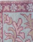 Lydia Oriental Pink Hand Knotted Wool Rug, a pink wool rug with an intricate oriental design, seen in a bright, naturally lit room.