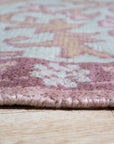 Lydia Oriental Pink Hand Knotted Wool Rug, showcasing intricate floral patterns woven in shades of pink and cream, softens a well-lit living space.