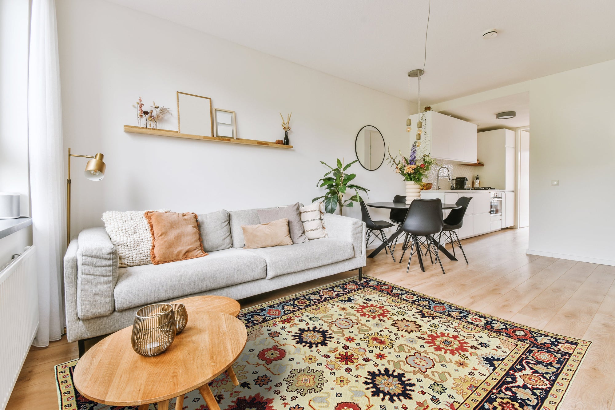 Violet Traditional Ivory Hand Knotted Wool Rug, displaying intricate floral patterns against a soft ivory backdrop, graces a warmly lit living space.