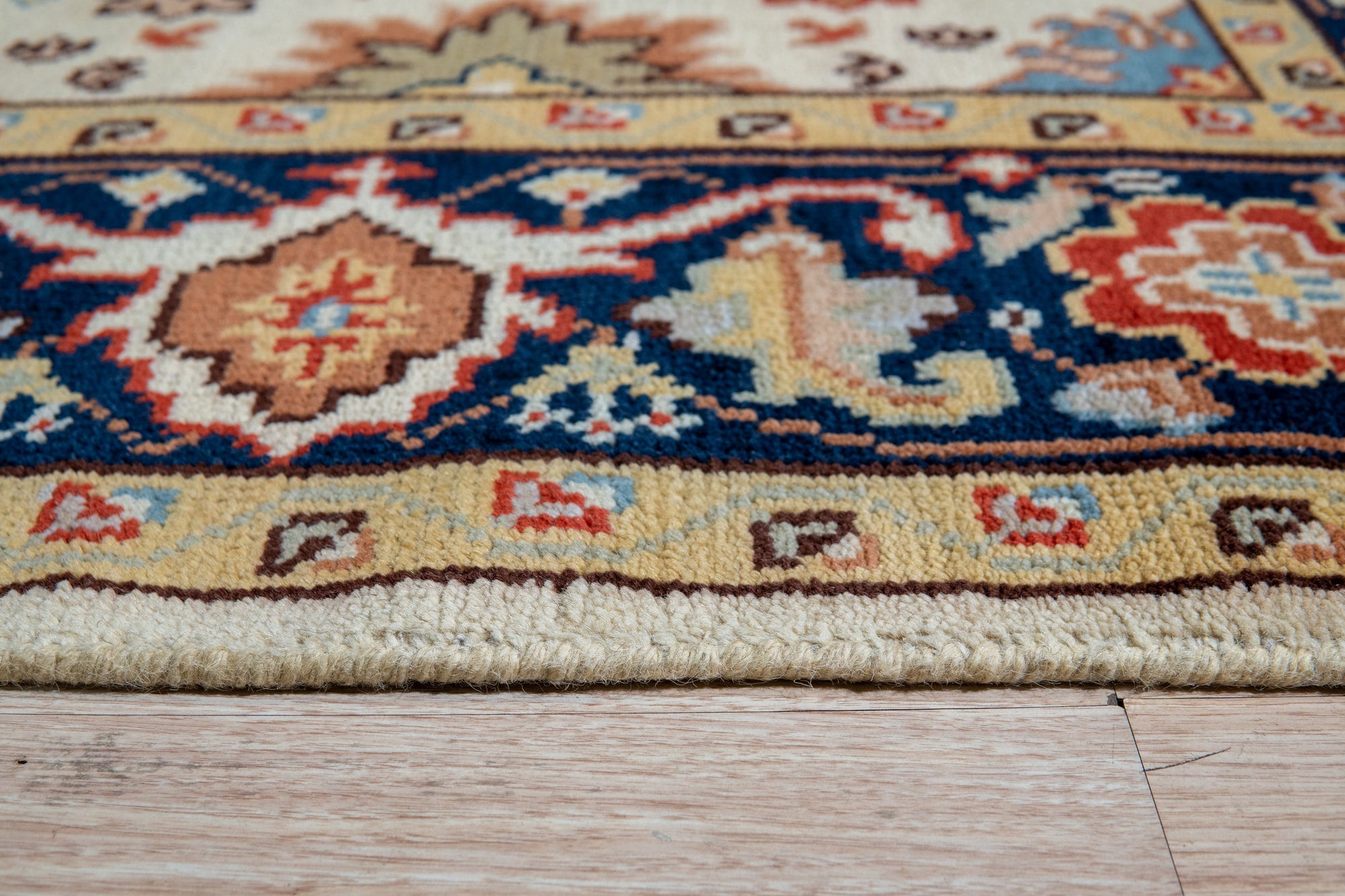 Handcrafted Xena Ivory Hand Knotted Wool Rug, a soft ivory wool rug featuring subtle geometric patterns, partially visible in a bright, airy living room setting.