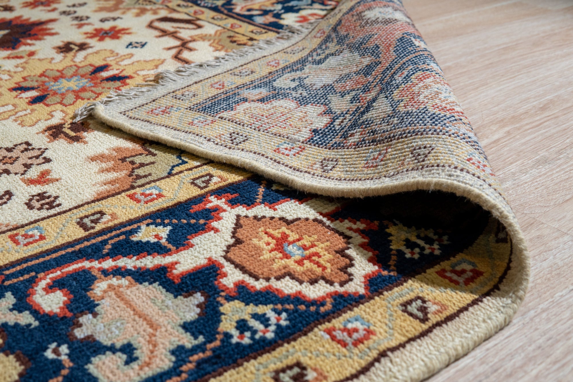 Handcrafted Xena Ivory Hand Knotted Wool Rug, its intricate hand-knotted wool texture and subtle ivory tones lending warmth and sophistication to a bright, modern living room setting with natural light.