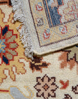 Handcrafted Xena Ivory Hand Knotted Wool Rug, its subtle ivory tones and intricate hand-knotted construction lending warmth to a comfortably styled living room with a dark wood coffee table and natural light.
