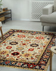 Violet Traditional Ivory Hand Knotted Wool Rug displayed in a well-lit living space. Hand-knotted wool construction highlights intricate floral patterns in ivory and subtle violet accents, complementing the room's neutral decor.