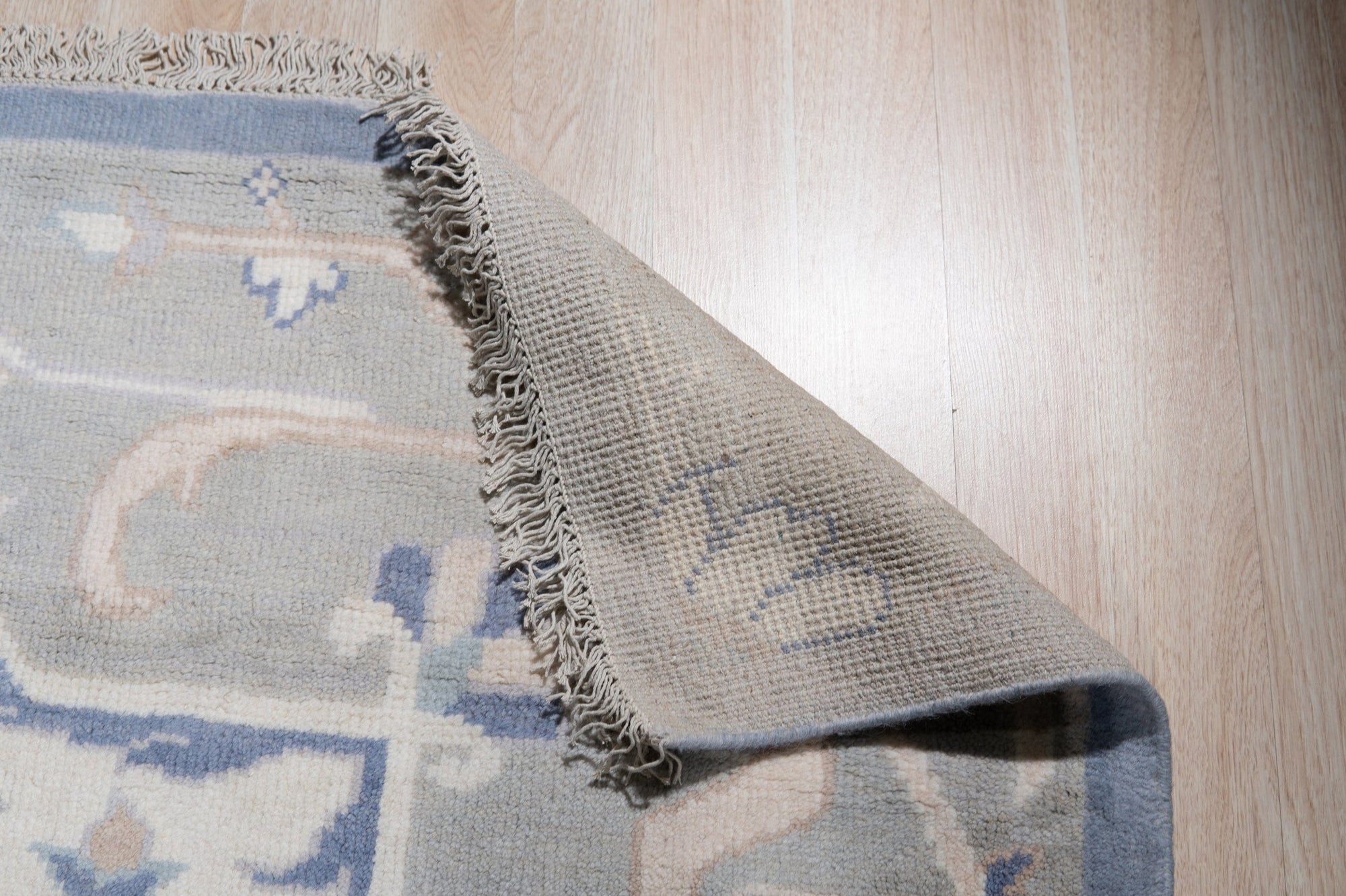 Stylish Trendy Ivory Hand Knotted Wool Rug, showing a detailed texture and subtle pattern in warm, inviting interior lighting.