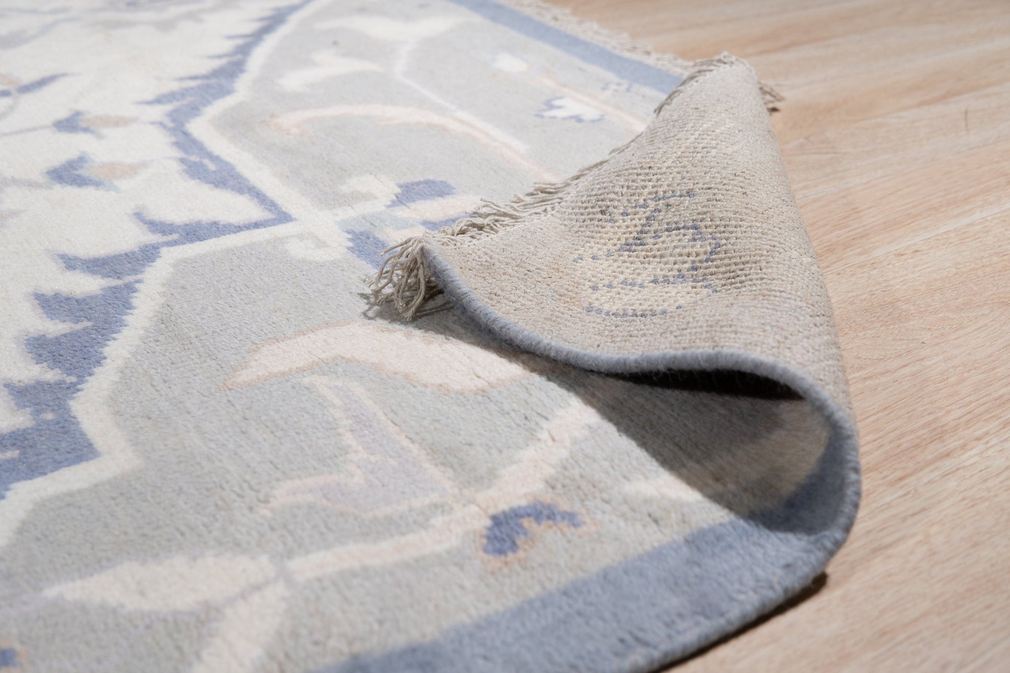 Stylish Trendy Ivory Hand Knotted Wool Rug, showcasing subtle variations in ivory hues and a soft, inviting texture in a bright, modern living room setting.