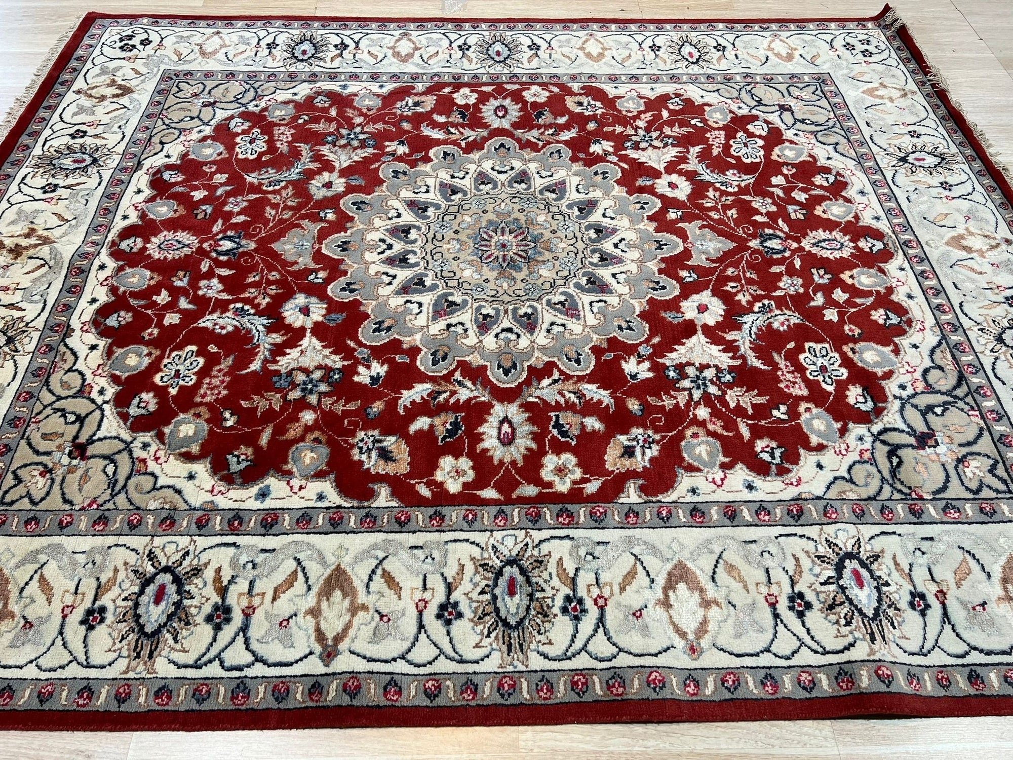 Selene Para Red Hand Knotted Wool & Silk Rug, a vibrant red and cream rug featuring an intricate, geometric design, seen in a well-lit living room setting.