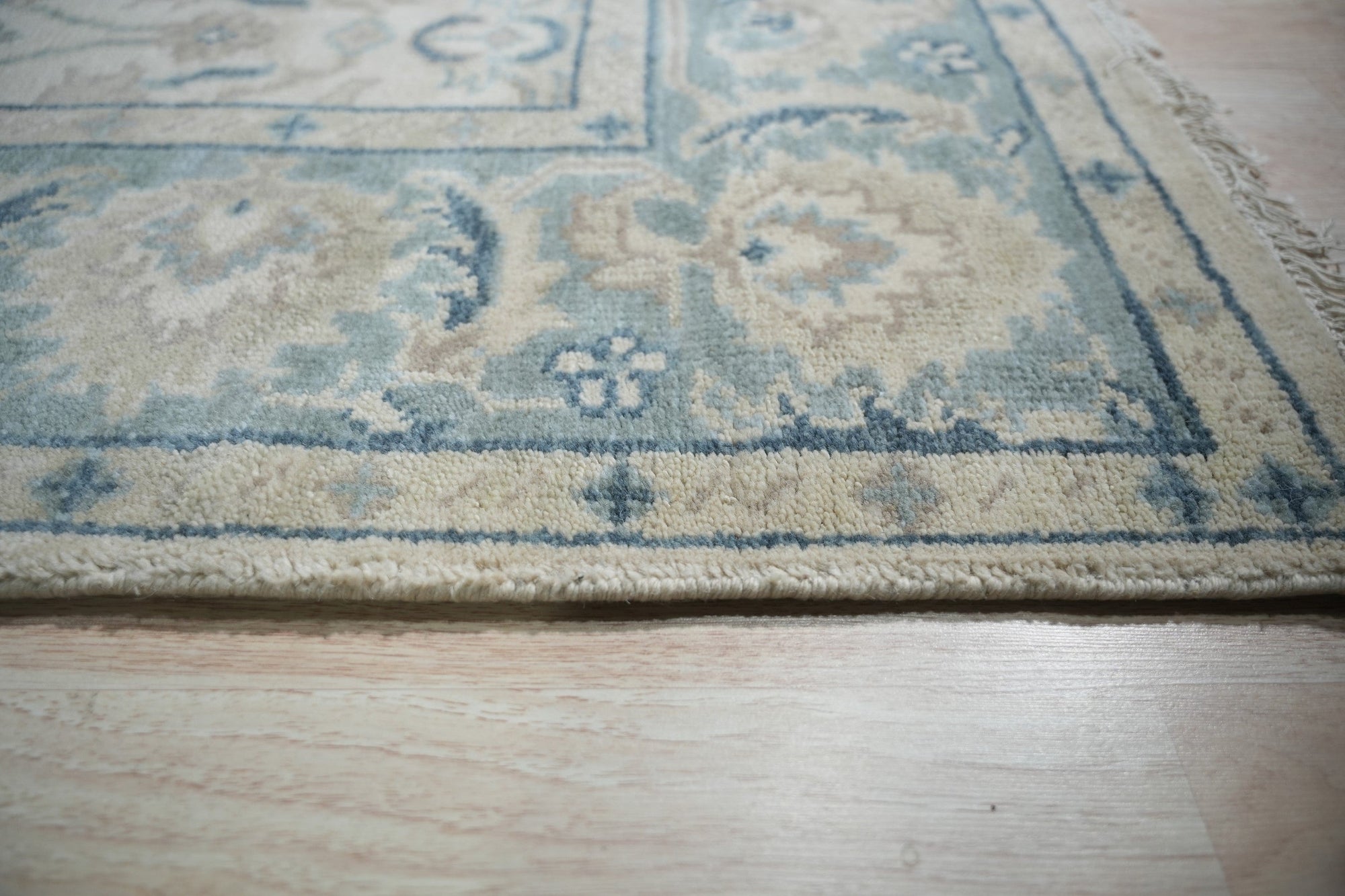 Celia Traditional Beige Hand Knotted Wool Rug, its intricate pattern and warm beige tones complementing a light-filled living space.