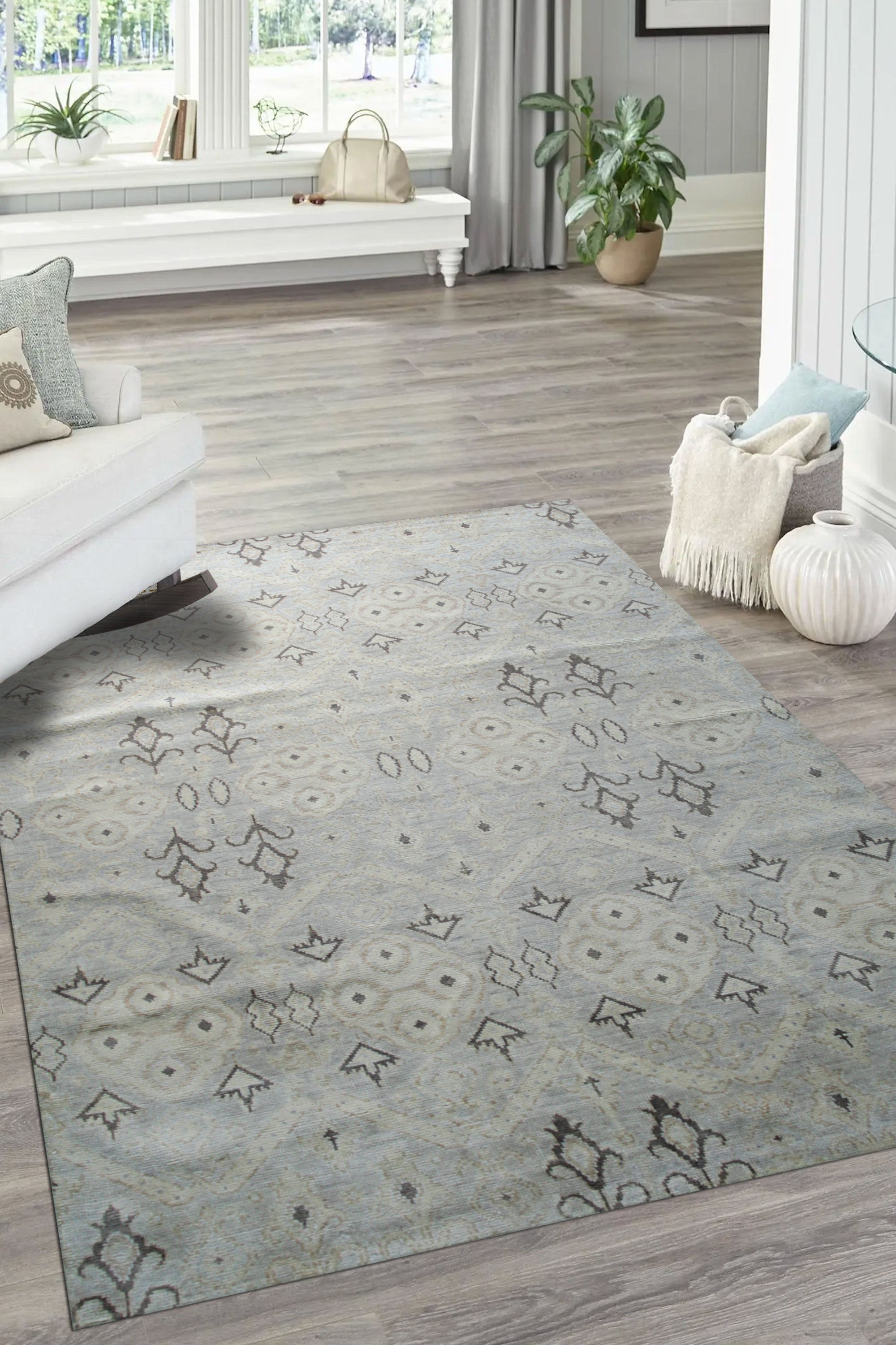 Lush Traditional Gray Hand Knotted Wool Rug, presenting intricate patterns in muted gray tones, rests on a light hardwood floor under warm, ambient lighting. The hand-knotted wool construction is evident in the detailed texture and subtle sheen.