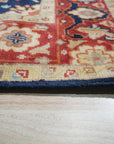 Chloe Amara Navy Hand Knotted Wool Rug, its intricate pattern and rich navy hues lending sophistication to a warmly lit living space.