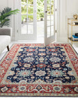 Chloe Amara Navy Hand Knotted Wool Rug, its intricate pattern unfolding across a softly lit floor, showcasing the rug's rich navy hues and textured wool construction within an elegant interior setting.