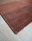 Isla Striped Rust Hand Tufted Wool Rug, warm rust tones and earthy stripes define this hand-tufted wool rug, grounding a bright living space with textural depth and visual interest.