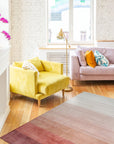 Isla Striped Rust Hand Tufted Wool Rug displayed on a light wooden floor, its warm rust and beige stripes adding textured comfort to the space. Hand tufted wool construction evident in the rug's plush pile.