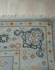 Captivating Timeless Light Blue Hand Knotted Wool Rug displayed in a bright living room setting, its delicate patterns and light blue hues complementing the surrounding furniture.