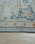 Captivating Timeless Light Blue Hand Knotted Wool Rug, soft light blue wool rug with intricate hand-knotted details, partially visible within a room setting.