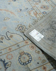 Captivating Timeless Light Blue Hand Knotted Wool Rug, its intricate pattern and soft light blue hues adding elegance to a brightly lit living space with hardwood floors and natural light.