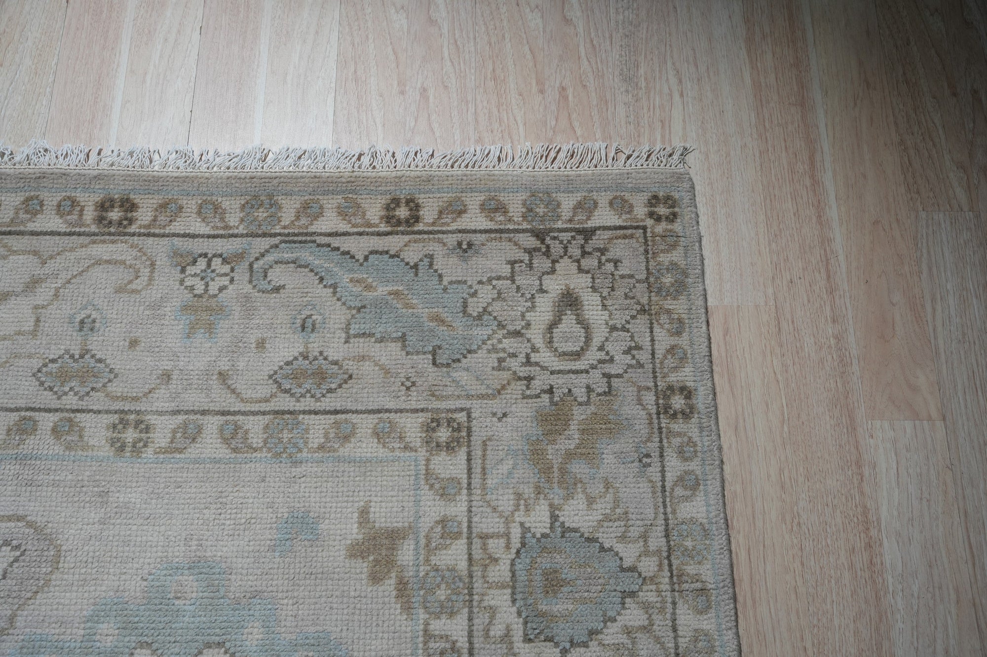 Classic Tessa Beige Nan Rug, showcasing its subtle beige tones and textured nan construction, nestled within a warmly lit living room setting.