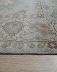 Classic Tessa Beige Nan Rug, a neutral beige rug with a subtle, geometric Nan design, showcased in a well-lit living room setting with contemporary furniture and ample natural light.