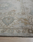 Classic Tessa Beige Nan Rug graces a warmly lit living room; soft beige hues and subtle, geometric patterns unfold across its woven surface, anchoring a comfortable seating area.
