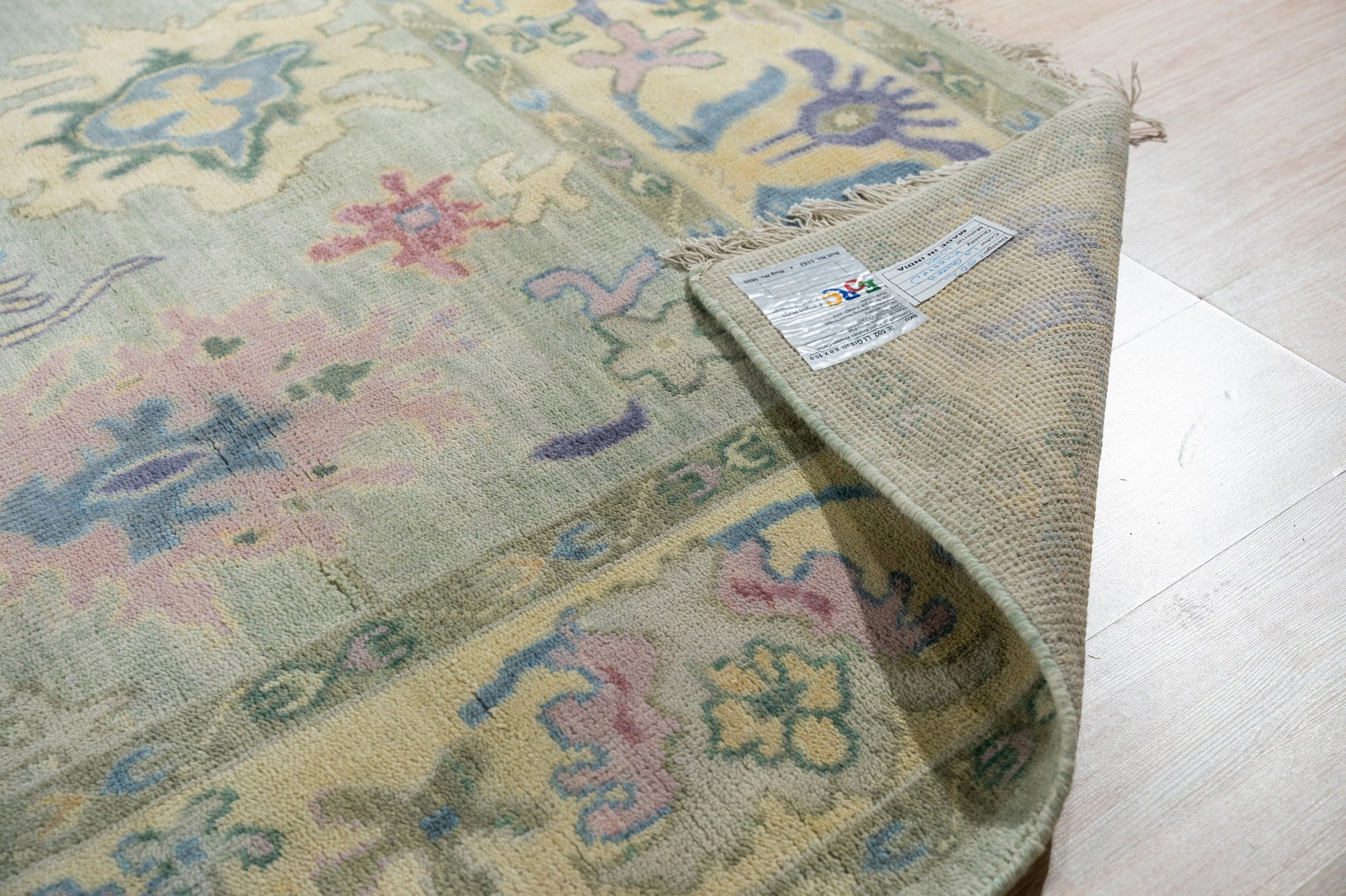 Elegant Timeless Light Green Hand-Knotted Wool Rug, its muted light green wool pile adding a touch of subtle luxury to a bright, airy room setting.