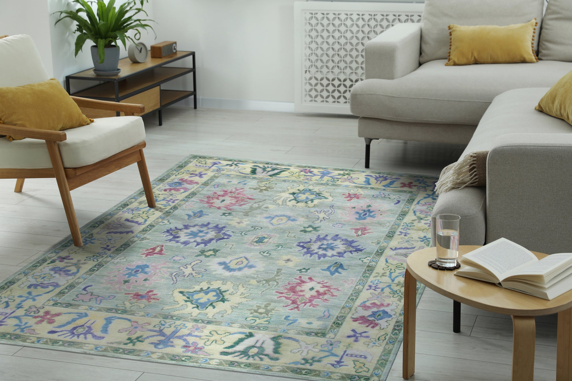 Elegant Timeless Light Green Hand-Knotted Wool Rug, showcasing its delicate, repeating floral pattern in a living room setting with natural light enhancing its subtle green hues.