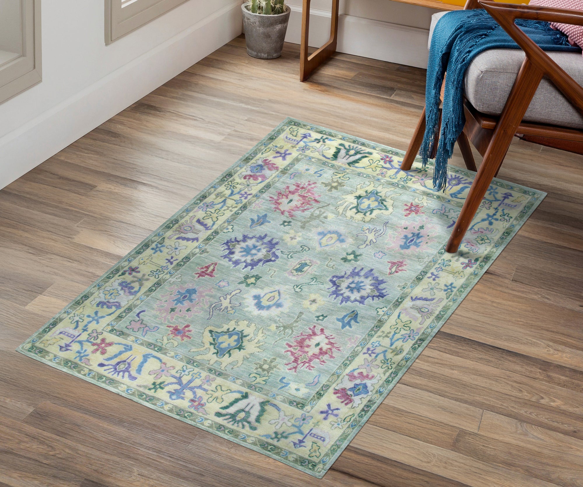 Elegant Timeless Light Green Hand-Knotted Wool Rug, showcasing its intricate, subtle patterns and soft light green hue, displayed on a hardwood floor in a warmly lit room.