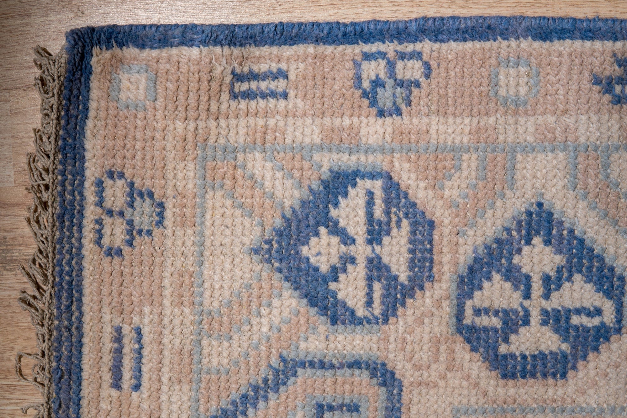 Bespoke Oriental Blue Hand Knotted Wool Rug, its intricate floral and geometric motifs rendered in shades of blue, cream, and hints of coral, filling a sunlit living space with warmth and pattern.