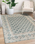 Luxurious Oriental Green Hand Knotted Wool Rug, its verdant hues and intricate design patterns spread across a warm hardwood floor, inviting comfort and timeless elegance into the room.