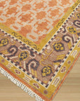 Jade Oriental Rust Hand Knotted Wool Rug, displaying intricate patterns and warm rust hues, sits gracefully within a bright interior space.