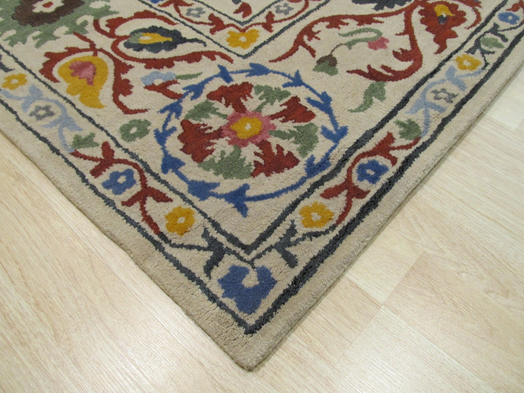 Ruby Fiona Ivory Hand Tufted Wool Rug, soft ivory wool rug with a subtle, geometric pattern, rests invitingly on a light hardwood floor, suggesting warmth and understated elegance.