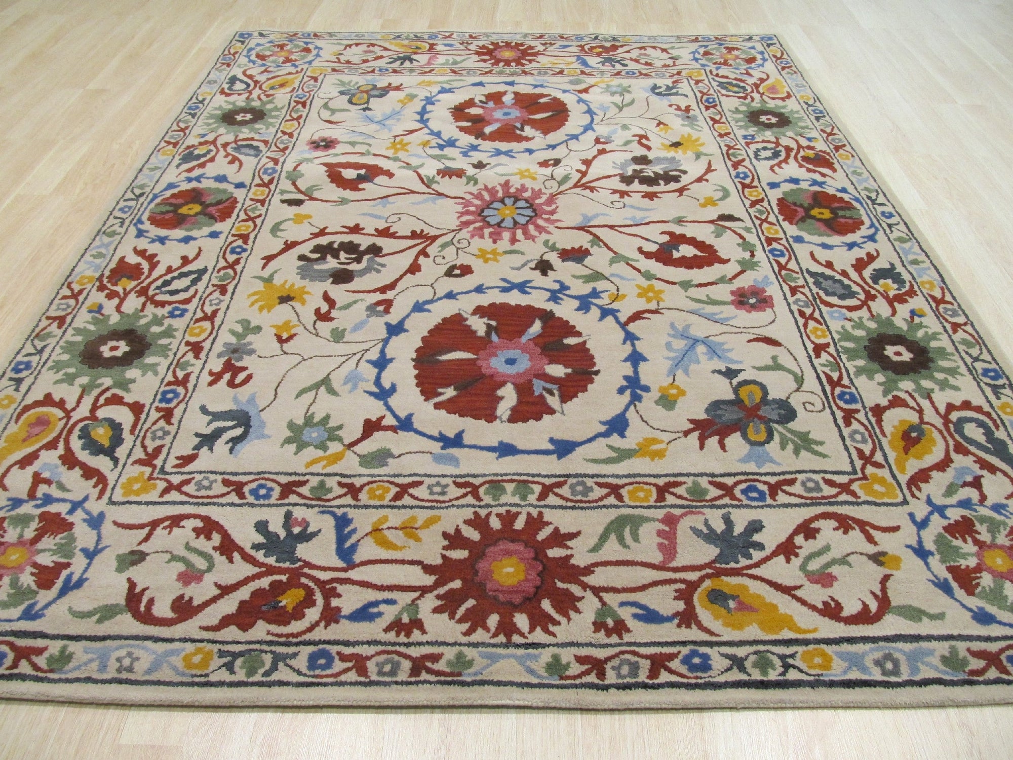 Ruby Fiona Ivory Hand Tufted Wool Rug, seen in a well-lit room, features a subtle, textured pattern in creamy ivory. Hand-tufted wool construction provides a soft, inviting surface.
