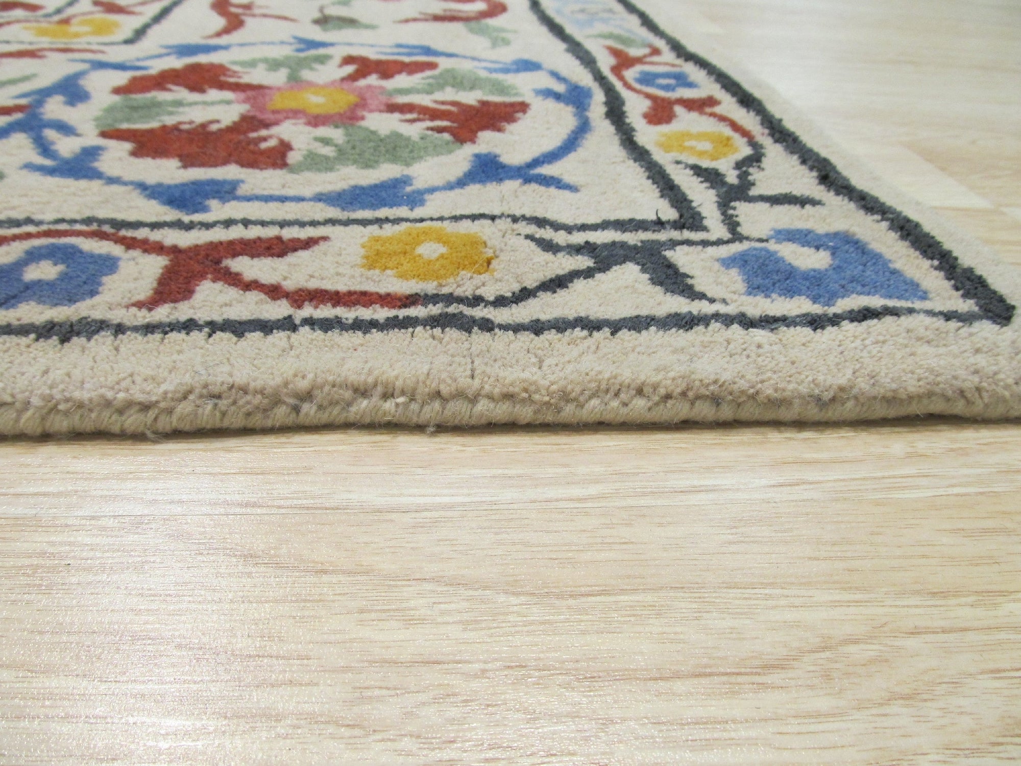 Ruby Fiona Ivory Hand Tufted Wool Rug, a soft ivory wool rug with a subtle, textured design, displayed in a bright, modern living room setting.