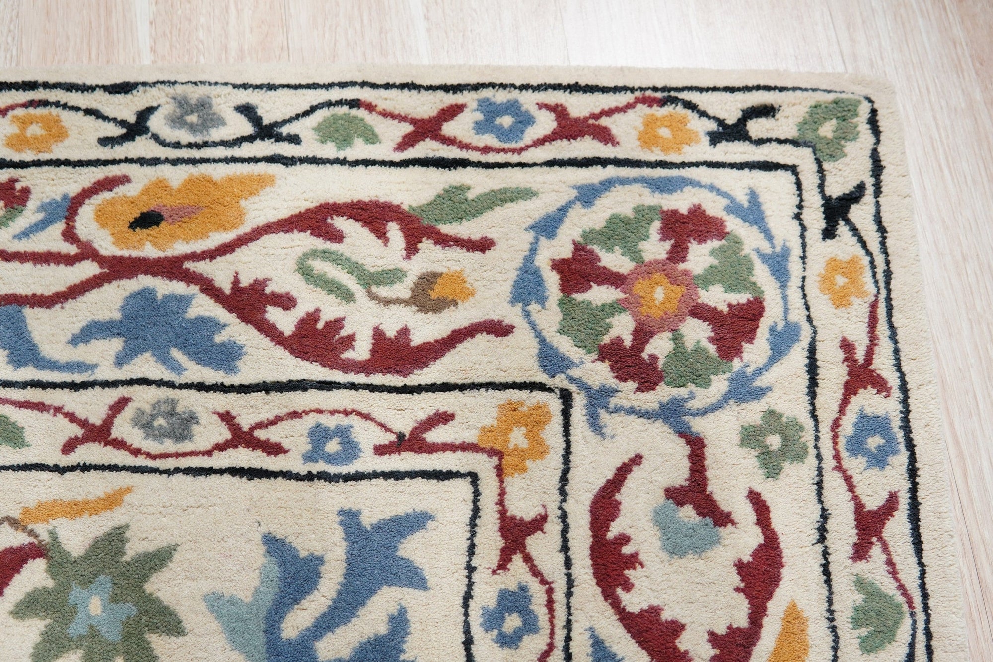 Ruby Fiona Ivory Hand Tufted Wool Rug, blending seamlessly into a bright living room with light wood floors, showcases its intricate pattern and soft, inviting texture.