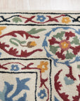 Ruby Fiona Ivory Hand Tufted Wool Rug, blending seamlessly into a bright living room with light wood floors, showcases its intricate pattern and soft, inviting texture.