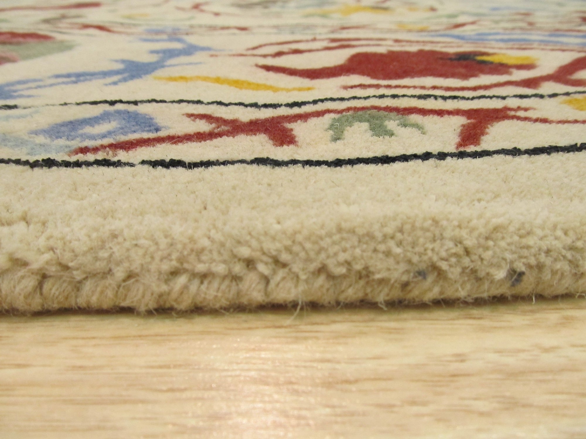Ruby Fiona Ivory Hand Tufted Wool Rug, features a subtle, textured design in soft ivory tones, its hand-tufted wool construction adding a plush and inviting element to a room setting.