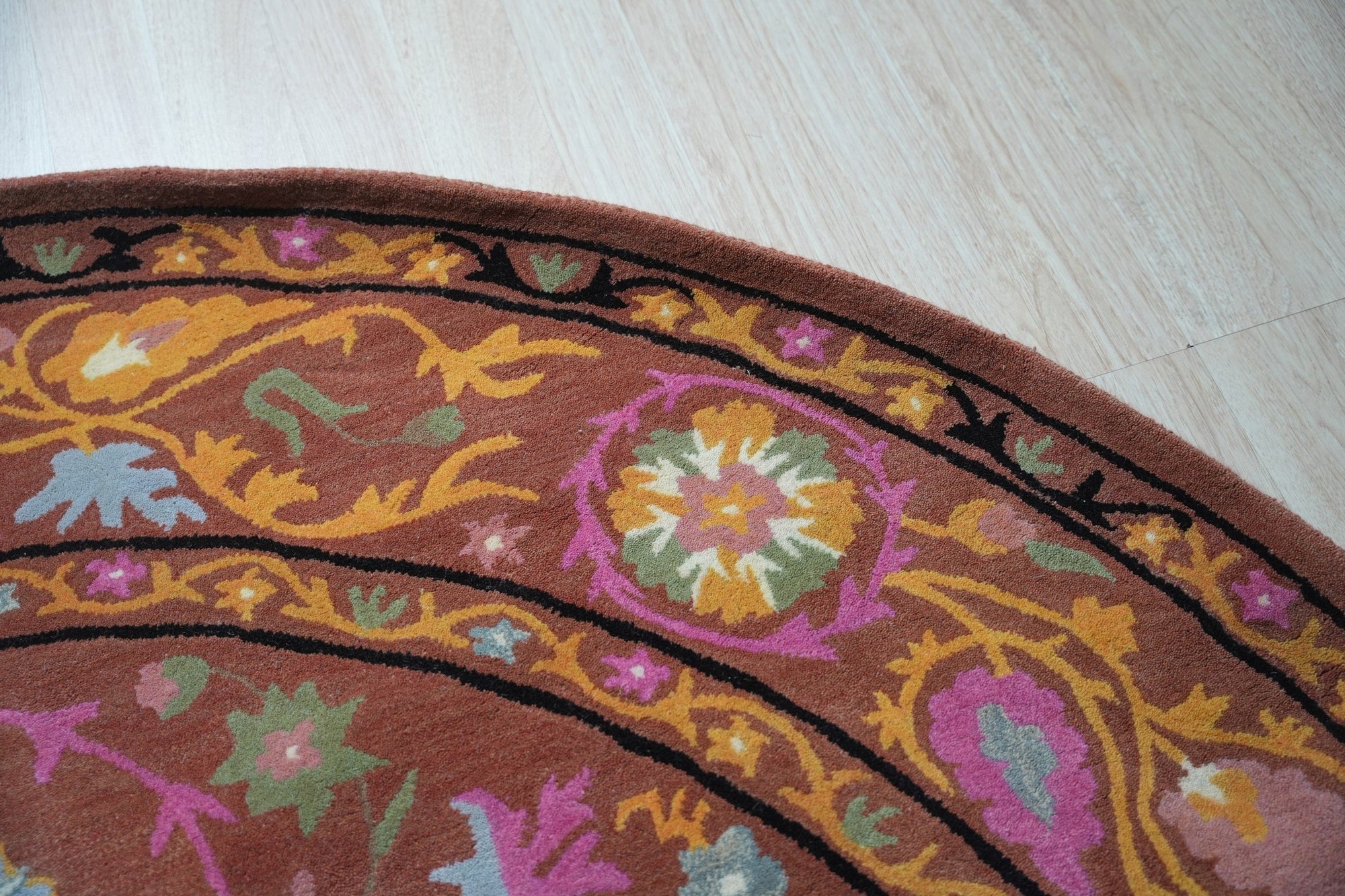 Willow Jade Rust Hand Tufted Wool Rug, its warm rust tones and soft jade accents lending an earthy elegance to a well-lit living space.