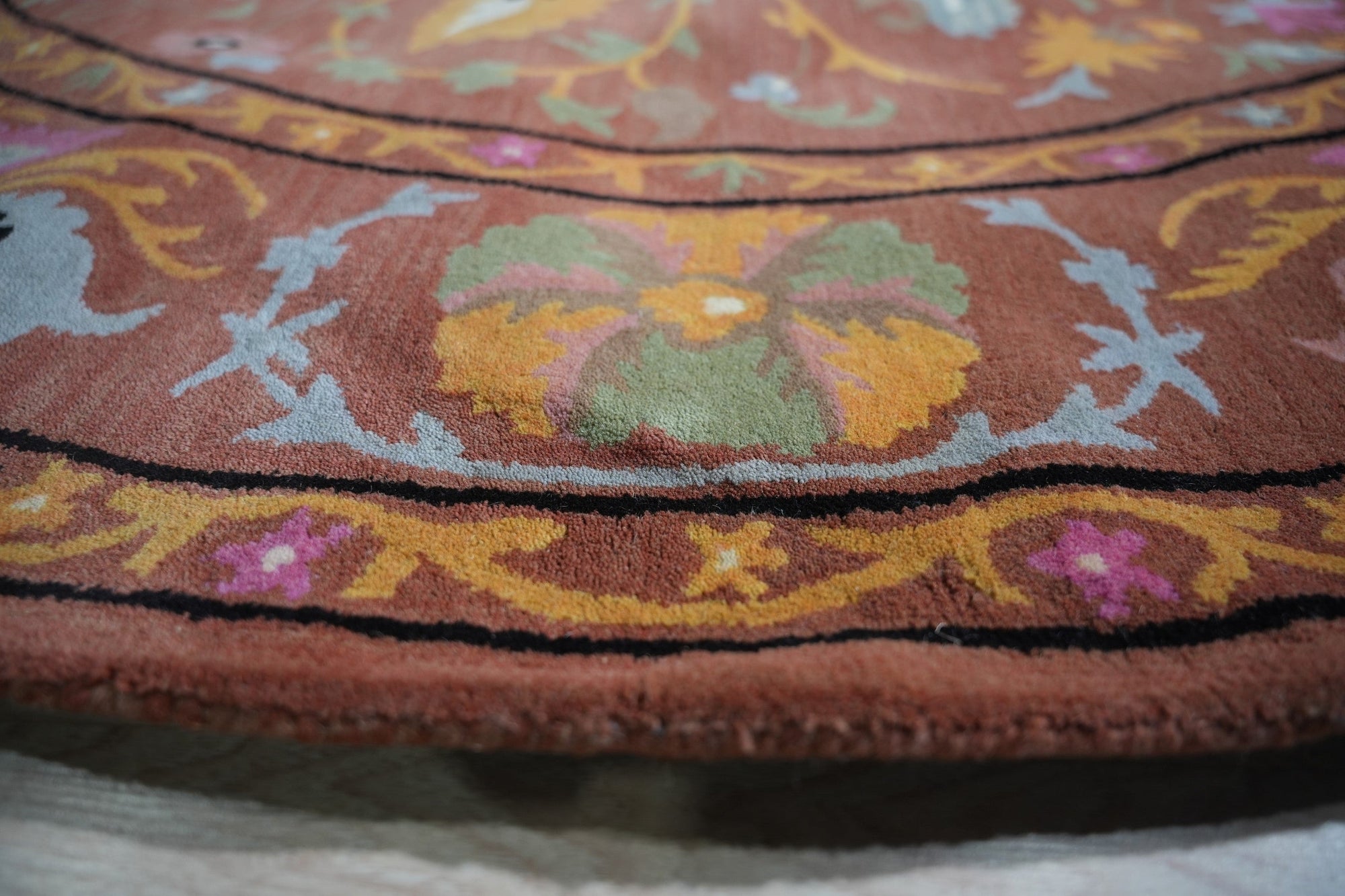 Willow Jade Rust Hand Tufted Wool Rug, displaying intricate patterns in jade, rust, and cream tones, positioned in a well-lit living room setting with complementary furniture.