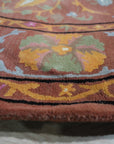 Willow Jade Rust Hand Tufted Wool Rug, displaying intricate patterns in jade, rust, and cream tones, positioned in a well-lit living room setting with complementary furniture.