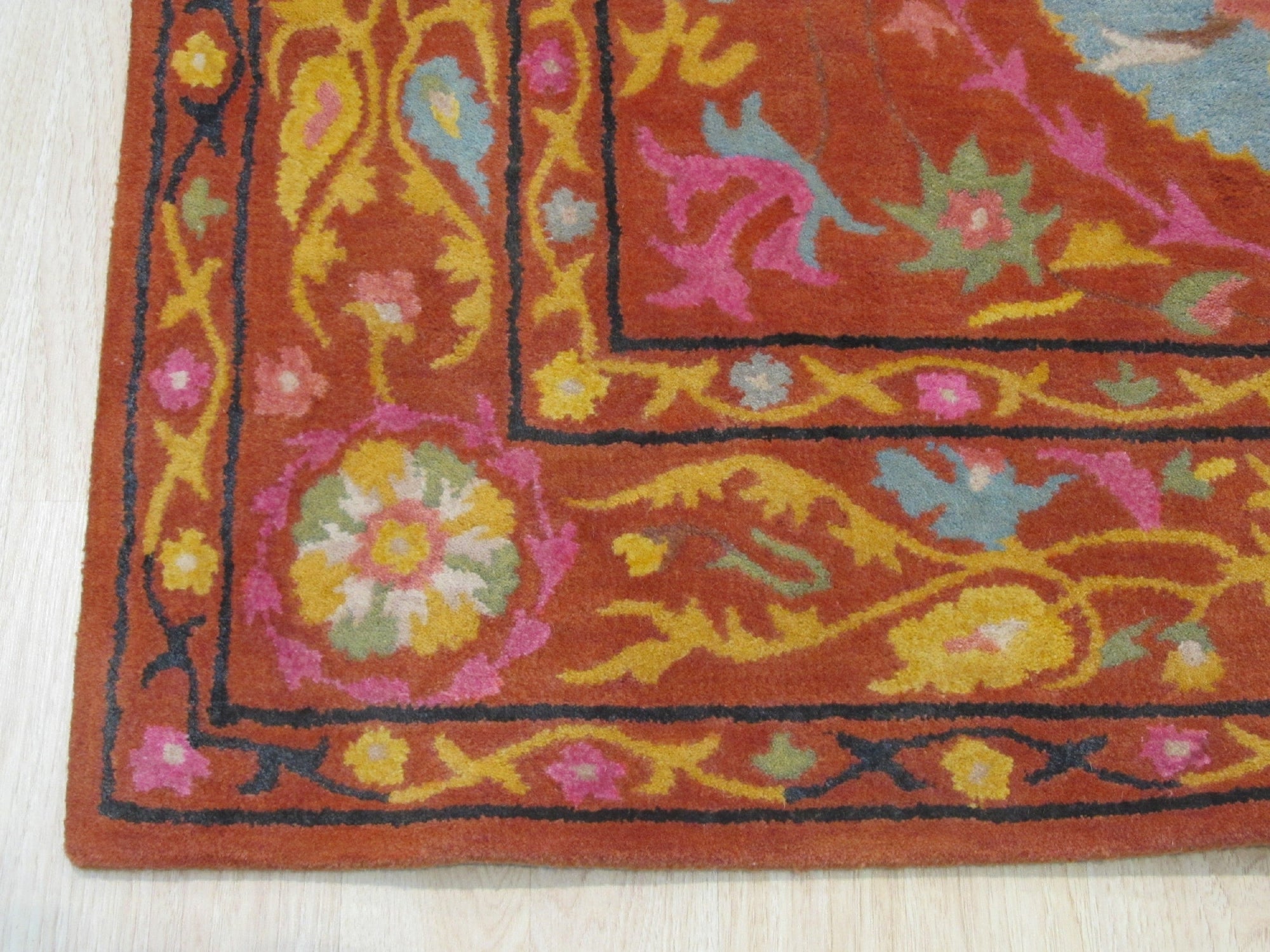 Willow Jade Rust Hand Tufted Wool Rug, blending jade greens and rusty oranges in a hand-tufted construction, displayed in a room setting.