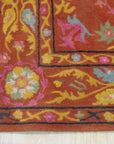 Willow Jade Rust Hand Tufted Wool Rug, blending jade greens and rusty oranges in a hand-tufted construction, displayed in a room setting.