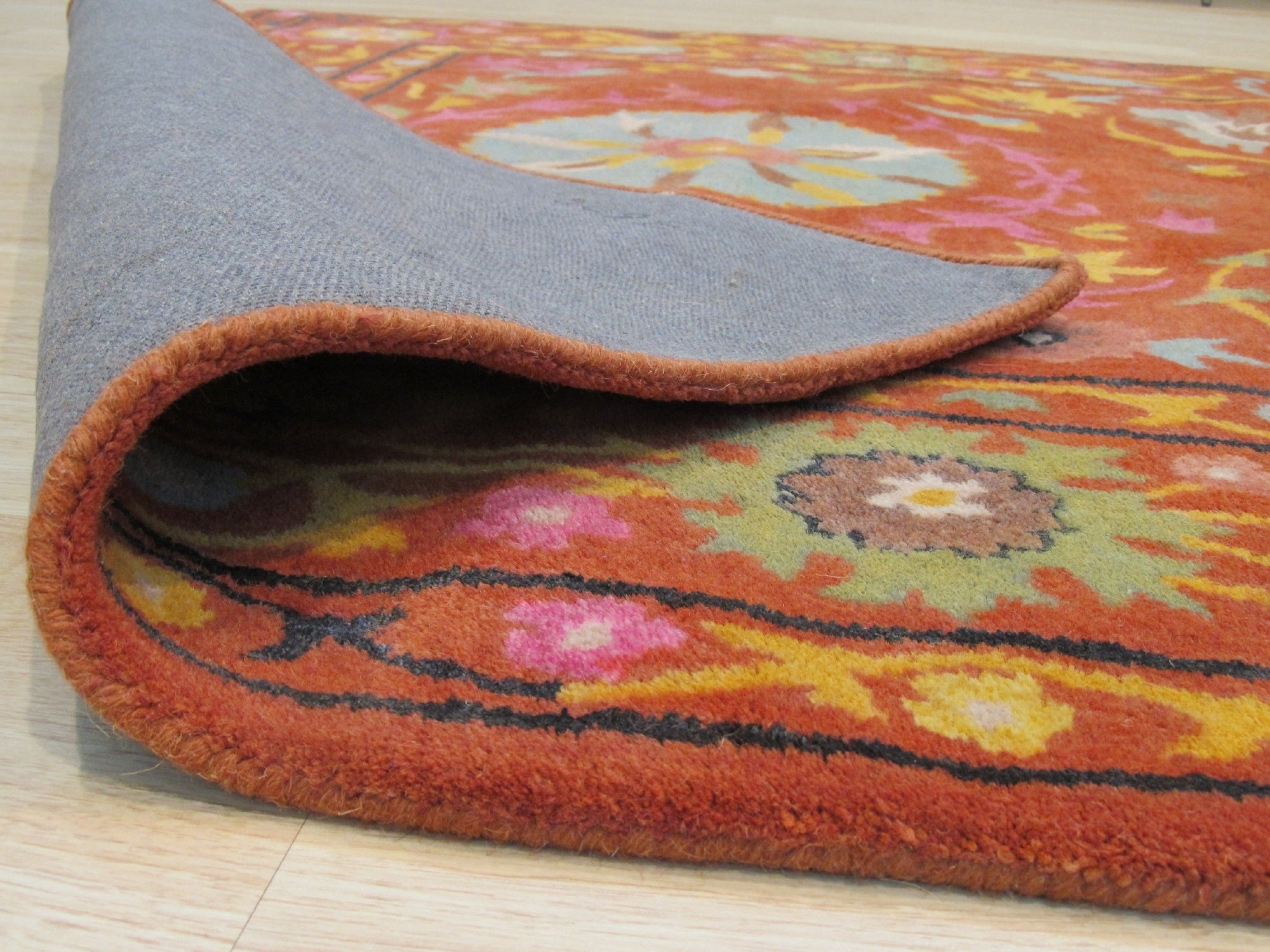 Willow Jade Rust Hand Tufted Wool Rug, showcasing earthy jade and rust tones in a hand-tufted construction, providing a touch of warmth and texture to a room setting.