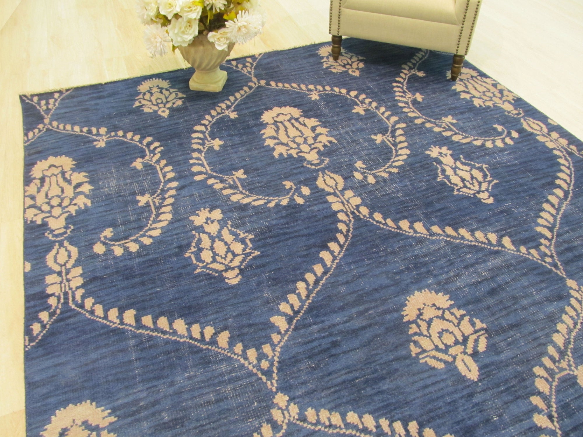 Luxurious Chloe Blue Hand Knotted Wool Rug, swirling patterns of deep blues and creams cascade across hand-knotted wool, displayed within a stylish living room setting.