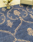 Luxurious Chloe Blue Hand Knotted Wool Rug, swirling patterns of deep blues and creams cascade across hand-knotted wool, displayed within a stylish living room setting.