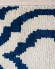 Trendy Moroccan Navy Hand Knotted Wool Rug, a deep navy and off-white wool rug with geometric Moroccan designs, displayed in a naturally lit living room setting.